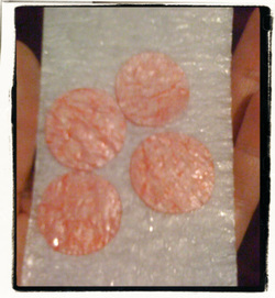 Discs of fused bubble wrap coloured pink.